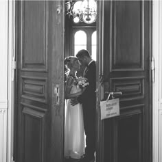 a bride and groom are standing in the doorway