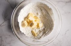 a bowl filled with flour and butter on top of a table