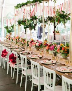 a long table with flowers and plates on it