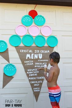 a young boy standing in front of a sign that says, crystal ice cream menu