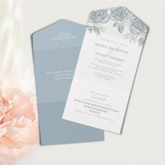 the wedding stationery is displayed next to a pink carnation and an open envelope