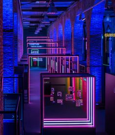 an empty room with purple lighting and neon signs on the walls in front of it