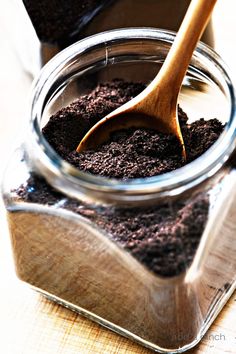 a jar filled with dirt and a wooden spoon