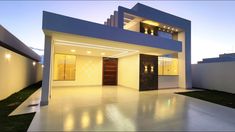 a modern house with white walls and lights on the front door is lit up at night