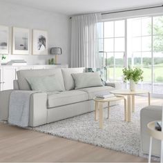 a living room filled with white furniture and lots of window sill space in front of it