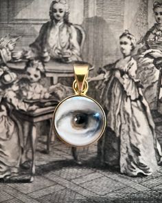 Lover's Eye pendant with an oil painting encased in gold plate over sterling with a quartz crystal cabochon which gives a magical magnifying effect, measuring 1/2" in diameter; 18" 16k gold over brass chain included. THE HISTORY: Lover's Eyes were a jewelry trend c.1785-1830 of brooches set with tiny watercolor portraits on ivory. Since they were cropped to eyes, they were in many ways more direct and intimate than traditional miniature portraits; but also because they were just eyes, they were Unique Gold Necklace For Memorial, Artistic Gold Jewelry With Large Pendant, Artistic Gold Round Jewelry, Artistic Gold Jewelry With Cabochon, Artistic Gold Necklace With Round Pendant, Gold Cabochon Round Pendant Jewelry, Spiritual Gold Necklace With Cabochon, Lover's Eye Jewelry, Unique Eye-shaped Jewelry For Gifts