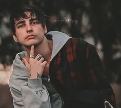 a young man is posing with his hand on his chin