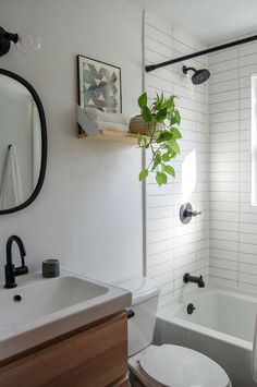 a bathroom with a toilet, sink and bathtub next to a mirror on the wall