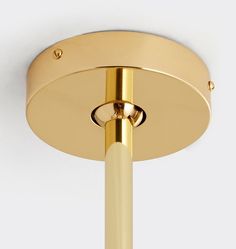 a close up of a light fixture on a white wall with a gold colored finish