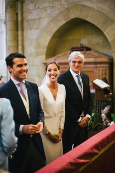 two men and a woman are standing in front of the alter