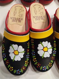 several pairs of shoes with painted flowers on them