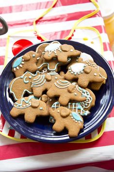 a plate full of decorated gingerbread cookies on a red and white tableclothed table cloth