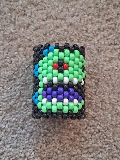 a colorful beaded object sitting on top of a carpet