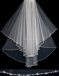 a white veil with beaded trim on it and a black background next to the veil