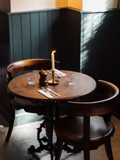 a table with two chairs and a candle on it