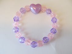 This is a Heart Beaded Bracelet. It has a purple pearl heart bead in the middle. It has pink and purple 8mm faceted beads. It was made with .8mm sturdy stretch string. I tie it several times to prevent breakage. It fits girls ages 4-8. It stretches to fit on the wrist. It would make a cute gift for a little girl for Valentine's Day.  All items are ready to be shipped I do combined shipping. Items ship in 2-5 business days. Check out more items at: http://www.etsy.com/shop/MesheleCrafts https://w Kids Bracelets, Pearl Heart, Jewellery Inspiration, Gift Valentine, Purple Pearl, Christmas Bracelet, Girl Jewelry, Bead Bracelets, Glass Beaded Bracelets