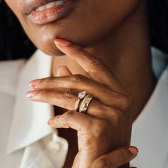 a close up of a person wearing a ring on her finger and looking at the camera