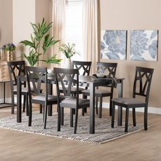 a dining room table and chairs with a rug on the floor