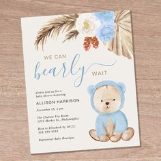 a bear themed baby shower is shown on a wooden surface with flowers and leaves in the background