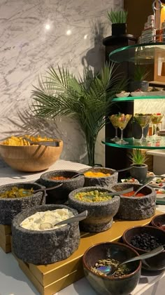 a table with bowls and plates of food on it in front of a display case