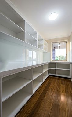 an empty room with white shelves and pineapples