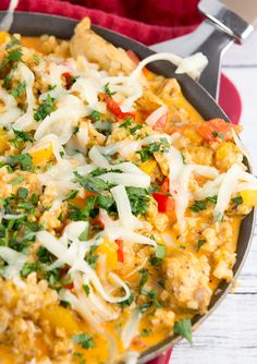 a skillet filled with chicken and rice covered in parmesan cheese