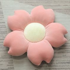 a pink flower shaped object sitting on top of a piece of paper