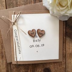 two wooden hearts are attached to a card