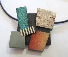 four different colored pieces of stone sitting on top of a white table next to a black cord