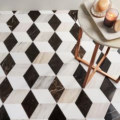 a table with two candles on it next to a black and white checkered floor