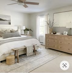 a bedroom with a bed, dresser and mirror