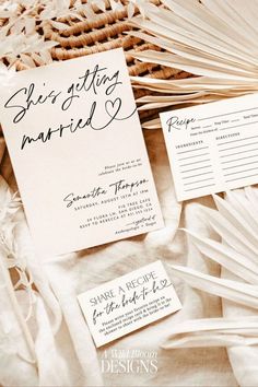 the wedding stationery is laid out on top of some fanned paper and other items