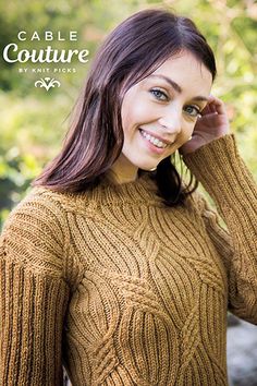 a woman wearing a brown cable knit sweater posing for a photo with her hand on her head