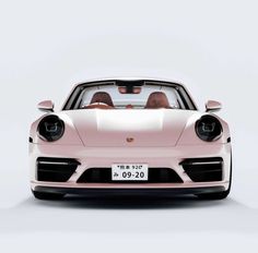 the front view of a pink porsche sports car with its hood up and two people in it