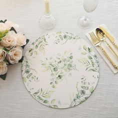 there is a place setting on the table with flowers and silverware next to it