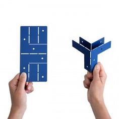 two hands holding up blue paper cutouts to show the shape of an airplane or plane