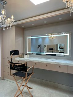 a chair and mirror in a room with chandeliers on the ceiling, lighting up