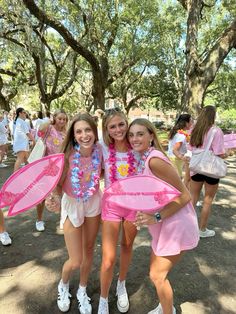 three girls dressed in pink and white are posing for the camera with their arms around each other