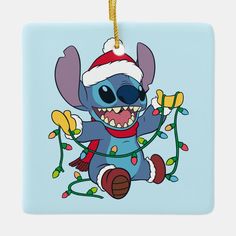 a blue square ornament with a cartoon character wearing a santa hat and lights