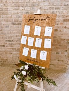 a wooden sign sitting on top of a white chair next to a flower pot filled with flowers