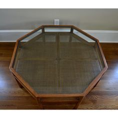 a wooden table with glass top on hardwood floor