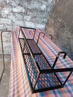 a metal bench sitting on top of a checkered blanket