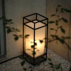 a lantern sitting on the ground next to a window