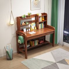 a wooden desk with books on it in front of a window and a rug next to it