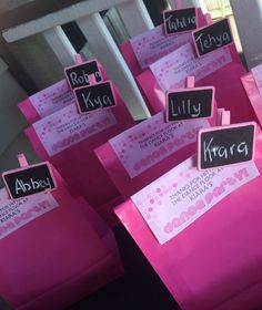 there are many pink bags with name tags on them