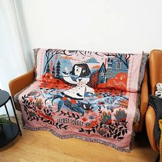 a couch covered in a colorful blanket sitting on top of a wooden floor