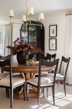 a dining room table with chairs and a potted plant on top of the table