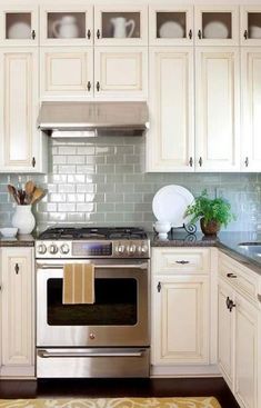 a kitchen with white cabinets and silver appliances