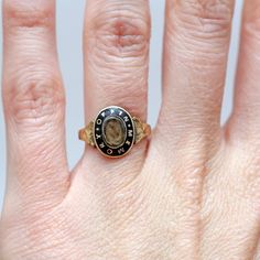 "Exquisite 10k gold and black enamel Victorian hair locket mourning ring. Ring face measures 12mm x 9.5mm and the words \"IN MEMORY OF\" encircle the memento locket. The enamel has been impeccably preserved. Ring size 3.24. Sizing available Layaway available" Heirloom Engraved Signet Ring For Memorial, Heirloom Memorial Engraved Signet Ring, Gold Oval Enamel Ring With Black Detail, Heirloom Jewelry With Polished Finish For Memorials, Antique Yellow Gold Signet Ring With Black Enamel, Victorian Oval Enamel Ring For Anniversary, Antique Engraved Ring For Memorial, Antique Black Enamel Signet Ring, Antique Oval Enamel Ring Collectible