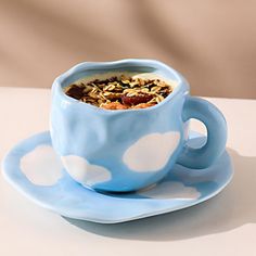 a blue cup filled with granola sitting on top of a saucer